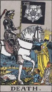The Death tarot card depicts a skeleton in black armor riding a white horse, carrying a black flag adorned with a white rose. People are shown kneeling before the figure, while the sun rises between two towers in the background.
