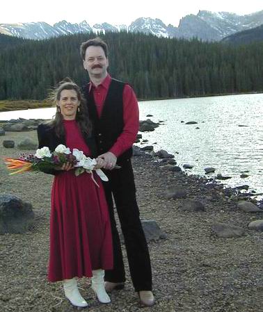 Our wedding photo. Our wedding photo. We are both wearing red and black on the shore of a mountain lake.
