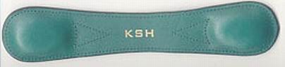 A green leather pad with rounded ends and the initials KSH embossed in gold at the center.