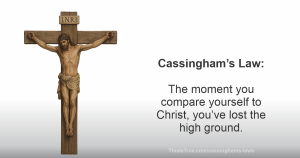 A wooden crucifix of Jesus is shown on the left. On the right, text reads: 'Cassingham’s Law: The moment you compare yourself to Christ, you’ve lost the high ground.'