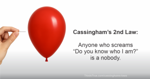 A hand holds a pin near a red balloon. Text reads: 'Cassingham’s 2nd Law: Anyone who screams Do you know who I am? is a nobody.'
