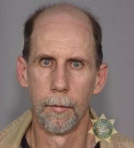 Mug shot showing a man with strangely intense eyes.