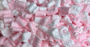 Close-up of a pile of pink and white packing peanuts, showing their textured, curled shapes.