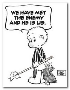 A cartoon possum character stands holding a stick with a bundle tied to it, next to a torn U.S. flag on the ground. A speech bubble reads, “We have met the enemy and he is us.” The cartoon is signed “Walt Kelly”.