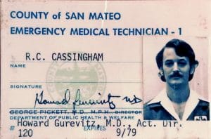 An emergency medical technician ID card for R.C. Cassingham from San Mateo County, featuring a headshot of Randy with a mustache and dark hair, official stamps, and several signatures. Expiration date: 9/79.