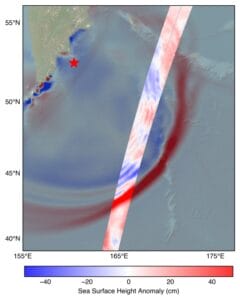 Map showing sea surface height anomaly near Japan, with a red star off the coast of the Kamchatka Peninsula showing the earthquake's location, and a vertical data swath showing variations from -40 cm (blue) to +40 cm (red). A color scale bar is at the bottom.