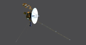 A spacecraft with a large white dish antenna, gold-colored components, and long extended rods against a gray background. It's NASA/JPL's Voyager 1 probe.