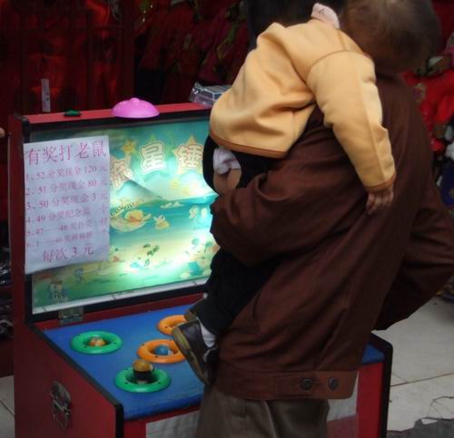 Playing Whack-a-Mole — while holding your baby in a busy market.